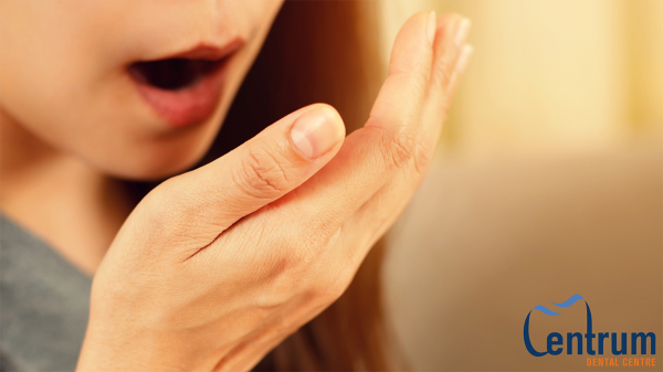 A women smelling her own breath.