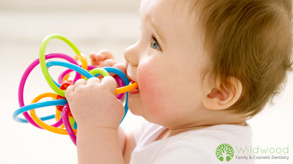 A baby chewing on a teething ring.